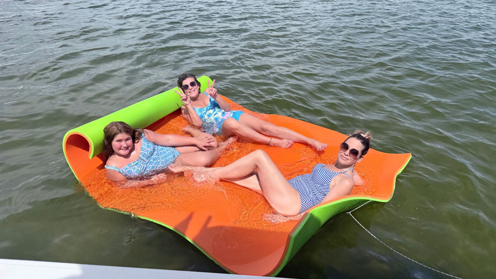 Large inflatable floating platform on water in Panama City FL with multiple people relaxing